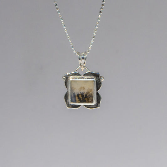 Silver pendant necklace on a gray background